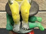 statue of a woman sitting on a stack of food on top of a wooden block