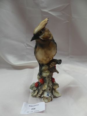 figurine en porcelaine représentant un oiseau perché sur une souche d'arbre