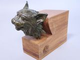 statue of a dog ' s head on a wooden block on a white background