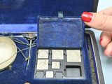 a woman ' s hand holding a silver object in a blue case