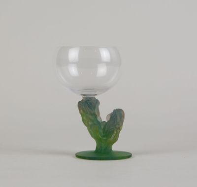 un verre contenant une plante, posé sur un socle