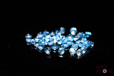 a close up of a bunch of blue crystals on a black surface