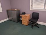 a desk with a phone and a chair in a room