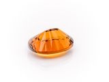 a close up of a faceted orange topazte stone on a white background