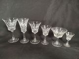 six glass goblets and four wine glasses on a black background