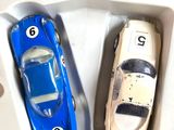 two toy cars in a plastic box with numbers on them