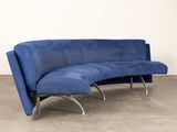 a blue couch with chrome legs and a curved back