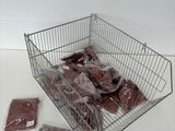 a metal basket filled with meat sitting on top of a table