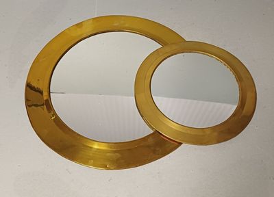 deux miroirs posés sur une table, sur fond blanc