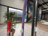 une grande salle de sport couverte équipée d'une pomme de douche violette et d'une autre violette