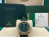 the rolex watch is green and gold with a green dial