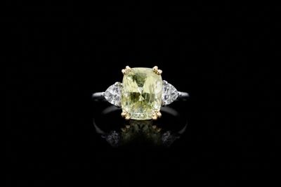 a yellow and white diamond ring on a black surface