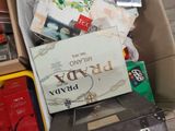 a cardboard box filled with assorted items on a wooden floor