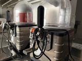 two beer kegs sitting on a counter in a kitchen