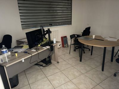 une pièce avec une table, des chaises et un ordinateur posé dessus
