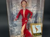 the doll is in a box with a picture of a woman in a red dress