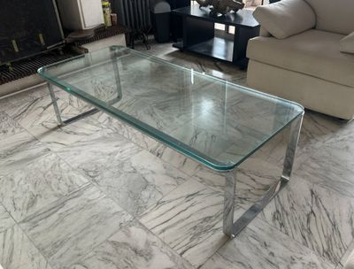 a glass coffee table in the middle of a living room