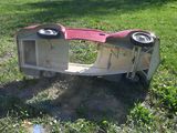 a red and white car that is upside down in the grass