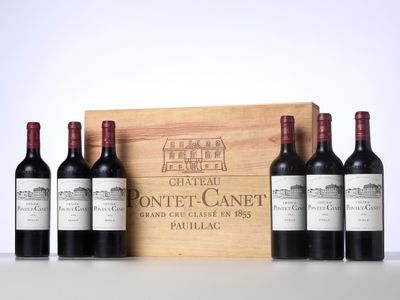 three bottles of red wine in front of a wooden box