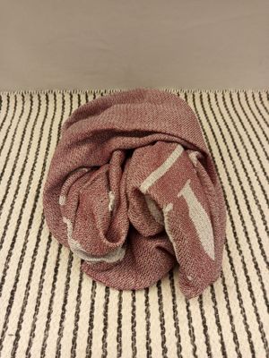 a towel on a bed with a striped blanket