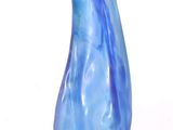 un vase en verre bleu posé sur une surface blanche