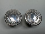 a pair of silverplated dishes on a table