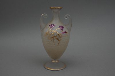 un vase blanc orné de fleurs violettes, posé sur une table