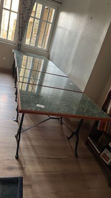 une longue table avec un plateau en verre au milieu d'une pièce