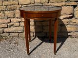 a small wooden table with a glass top on a gravel ground