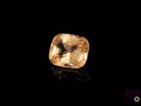 un diamant jaune sur une surface noire dans l'obscurité