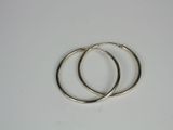 two silver hoop earrings on a white surface