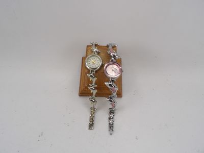 Lot de 2 montres bracelets en métal à décor de dauphins.