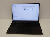 L'ordinateur portable est posé sur une table blanche équipée d'un clavier noir.