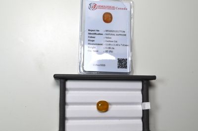 Un saphir jaune, facetté coussin, d'un poids de 11,96 cts, a…