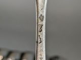 a spoon with a fork on it sitting in front of a bunch of spoons
