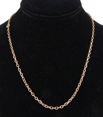 un collier à chaîne en or avec un maillon ovale autour du cou d'un mannequin