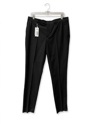 the black pants are hanging on a hanger on a white wall