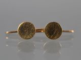 a pair of gold earrings on a white surface