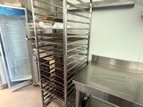a metal rack with trays of food in a kitchen
