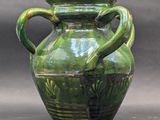 a green vase with a handle on a gray background