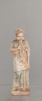 une statue représentant un homme jouant de la flûte, posée sur une table