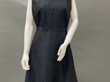 a mannequin wearing a black dress with a collar