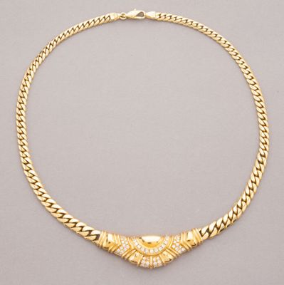 a gold necklace with a diamond clasp on a chain