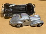 une petite voiture argentée et une autre petite voiture argentée posées sur une table