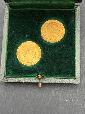 une image représentant deux pièces d'or dans un écrin en velours vert