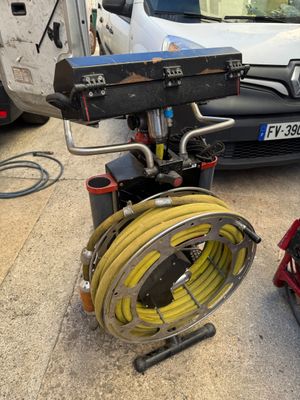 a fire hydrant and a hose on the ground next to a car