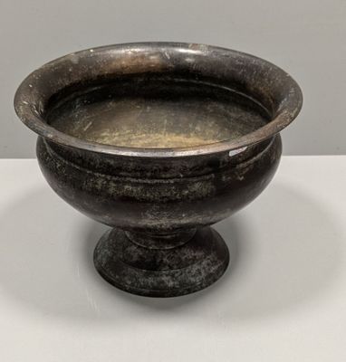 un bol noir posé sur une table blanche