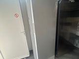 a refrigerator and a freezer in a room with a lot of boxes