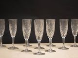 six empty wine glasses lined up on a table against a black background