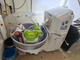 une photo d'une cuisine avec une machine à laver et une poubelle